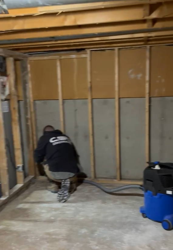 Ouvrier professionnel effectuant la démolition et le retrait d'un plancher de bois franc dans une résidence en rénovation à Montréal par AdréCo.