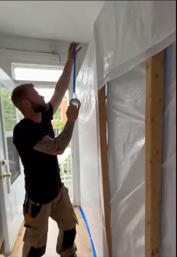 Installation d'une barrière de confinement en polyéthylène par un expert d'AdréCo en décontamination pour isoler une zone de décontamination d'amiante.